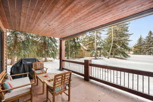 Snow covered patio with outdoor lounge area and area for grilling