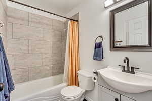 Full bathroom with vanity, toilet, and shower / bathtub combination with curtain