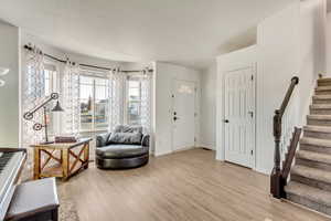 Foyer with a textured ceiling and light wood-type flooring