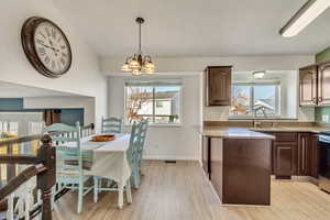 Kitchen with light hardwood / wood-style flooring, a notable chandelier, a healthy amount of sunlight, and sink