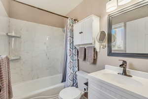 Full bathroom featuring shower / tub combo, vanity, and toilet