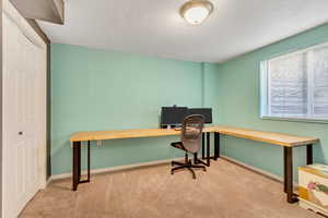 Carpeted office space with built in desk