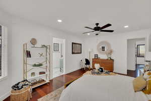 Bedroom with ceiling fan, dark hardwood / wood-style flooring, and ensuite bath