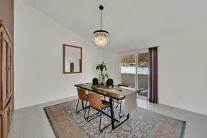 Dining room featuring vaulted ceiling and an inviting chandelier