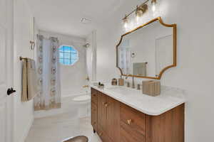 Full bathroom featuring shower / bath combination with curtain, vanity, and toilet