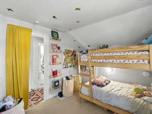 Carpeted bedroom featuring lofted ceiling