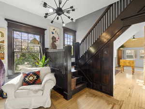 Staircase with a chandelier, hardwood  and plenty of natural light