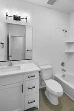 Full bathroom with vanity,  shower combination, tile patterned floors, and toilet