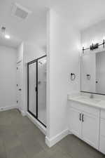 Bathroom with tile patterned flooring, vanity, and a shower with shower door