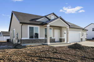 View of front of property featuring central AC unit and a garage