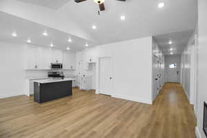 Kitchen featuring a center island with sink, white cabinets, light hardwood / wood-style flooring, and appliances with stainless steel finishes