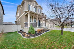 View of front facade with covered porch and a front lawn