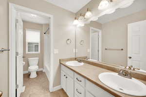 Bathroom with tile patterned flooring, vanity, and toilet