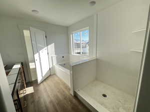 Bathroom featuring hardwood / wood-style floors, vanity, separate shower and tub, and a textured ceiling