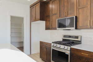 Kitchen featuring stainless steel appliances, decorative backsplash, and light hardwood / wood-style floors