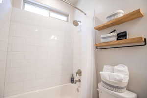 Bathroom featuring shower / tub combo and toilet