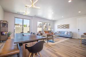 Dining room with a textured ceiling, light hardwood / wood-style flooring, and a notable chandelier