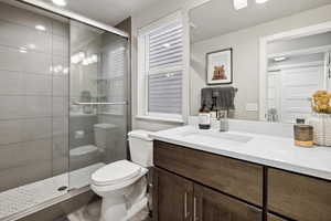 Bathroom with vanity, toilet, and walk in shower