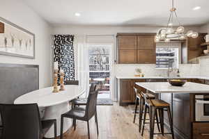 Dining room featuring a notable chandelier, plenty of natural light, light hardwood / wood-style floors, and sink