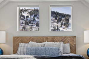 Bedroom featuring lofted ceiling and multiple windows