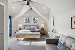 Carpeted bedroom featuring lofted ceiling with beams and ceiling fan