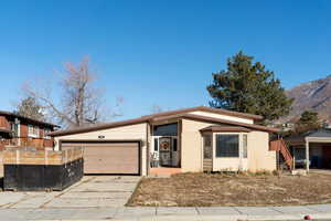 View of front of property with a mountain view and a garage