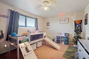 Carpeted bedroom featuring ceiling fan