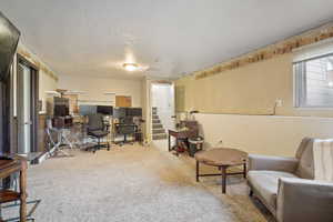 Carpeted home office featuring a textured ceiling