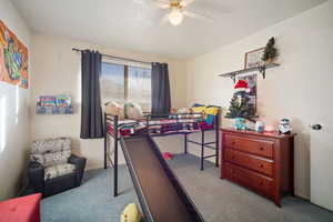 Carpeted bedroom featuring ceiling fan