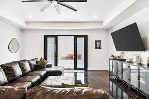 Living room featuring a tray ceiling and ceiling fan