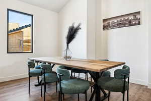 Dining room with lofted ceiling and wood-type flooring