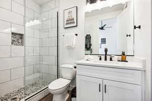 Bathroom featuring vanity, toilet, and a baseboard heating unit