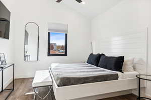 Bedroom featuring ceiling fan, vaulted ceiling, and hardwood / wood-style flooring