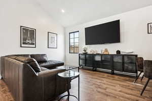 Living room with wood-type flooring and lofted ceiling