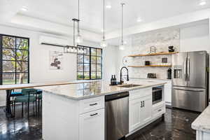 Kitchen with plenty of natural light, sink, white cabinetry, and stainless steel appliances