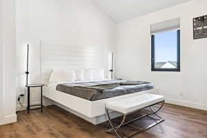 Bedroom with wood-type flooring and vaulted ceiling