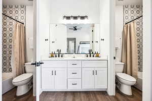 Full bathroom featuring ceiling fan, hardwood / wood-style floors, shower / bath combo, and toilet