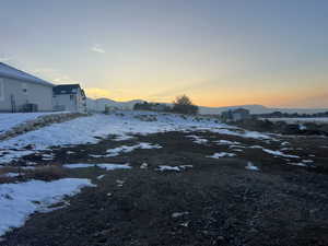 Yard layered in snow featuring a mountain view and central AC