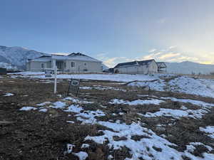 Yard covered in snow featuring a mountain view