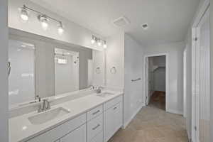 Bathroom featuring vanity, tile patterned floors, and a shower with shower door