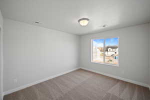 Spare room featuring carpet and a textured ceiling