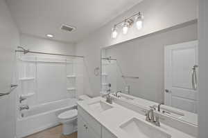 Full bathroom featuring tile patterned floors, toilet, vanity, and tub / shower combination