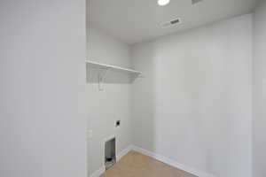 Laundry room featuring light tile patterned flooring and hookup for an electric dryer