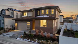 View of front of house with central air condition unit and a garage