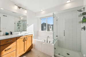 Bathroom featuring separate shower and tub and vanity