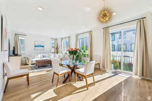 Dining area featuring light wood-type flooring, an inviting chandelier, and plenty of natural light