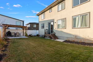 Back of house with a yard and a patio