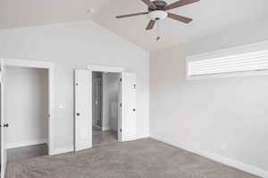 Unfurnished bedroom featuring carpet, ceiling fan, and lofted ceiling