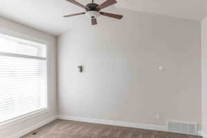 Spare room featuring ceiling fan, a healthy amount of sunlight, and light carpet