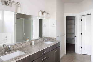 Bathroom featuring tile patterned flooring, vanity, and separate shower and tub